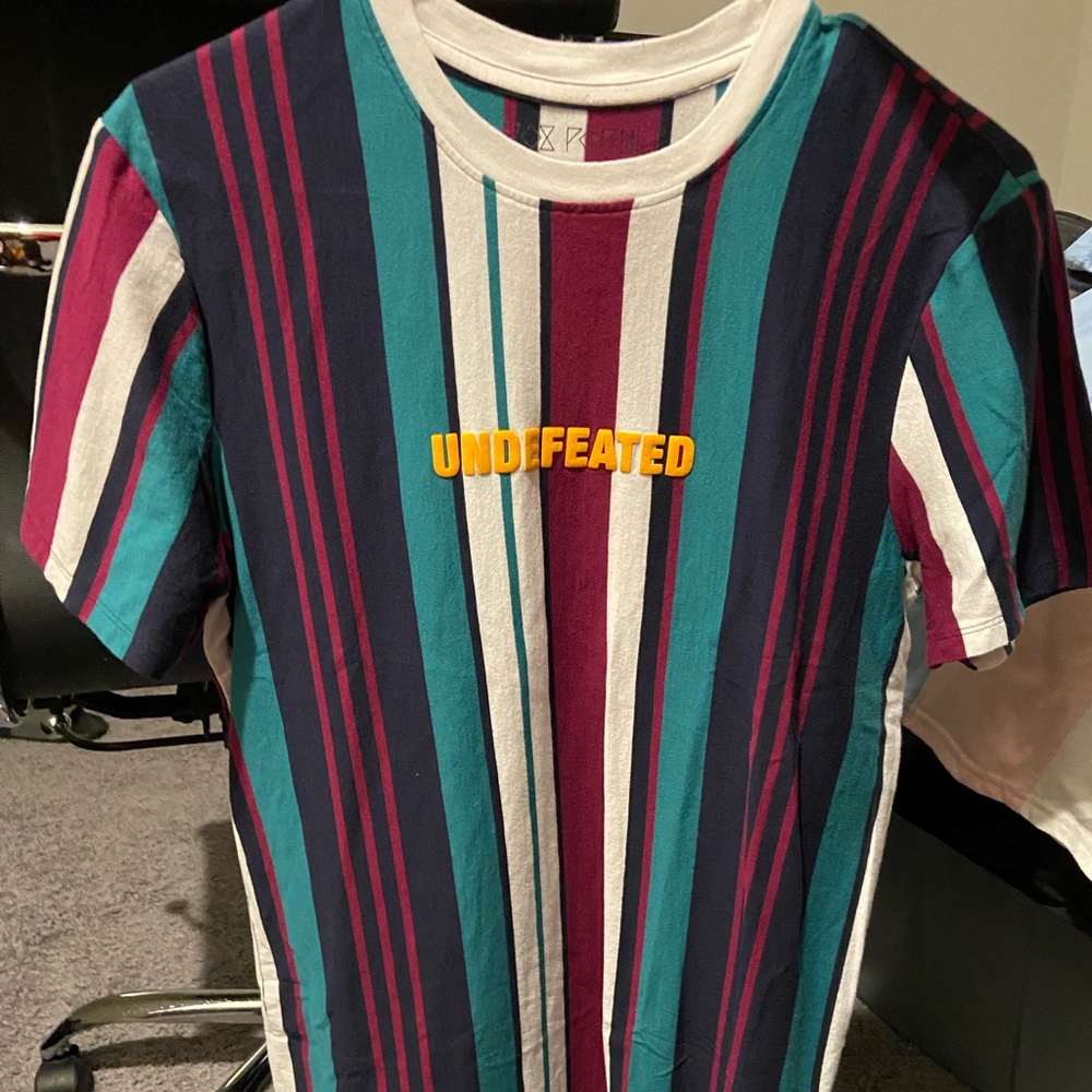 Undefeated t-shirt. Multi colored striped shirt